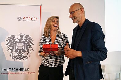 Sektionsvorsitzender Plöderl bei der Übergabe eines süßen Dankeschöns in Form einer Linzer Torte an Referentin Kaestle © Foto: Arch+Ing